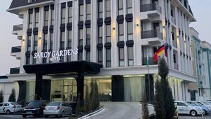 A multi-story hotel with a modern facade, large windows, and a prominent entrance. - Saroy Gardens Hotel (Fergana)