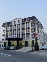 Un hotel de varios pisos con fachada moderna, grandes ventanales y una entrada destacada.