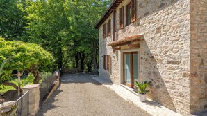 A stone building with a gravel path leading to a wooden door. - Villetta Cafaggio Ac Panzano In Chianti (Castellina in Chianti)