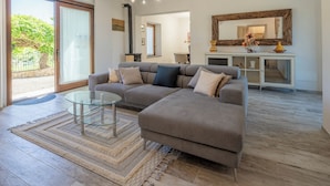 A modern living room with a sectional sofa, glass coffee table, and a large mirror above a console table. - Villetta Cafaggio Ac Panzano In Chianti (Castellina in Chianti)