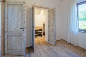 Eine Holztür zu einem Schrank mit Regalen und einer Kleiderstange.