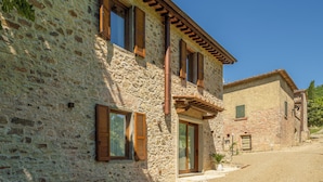 A stone building with wooden shutters, a chimney, and a small garden area. - Villetta Cafaggio Ac Panzano In Chianti (Castellina in Chianti)
