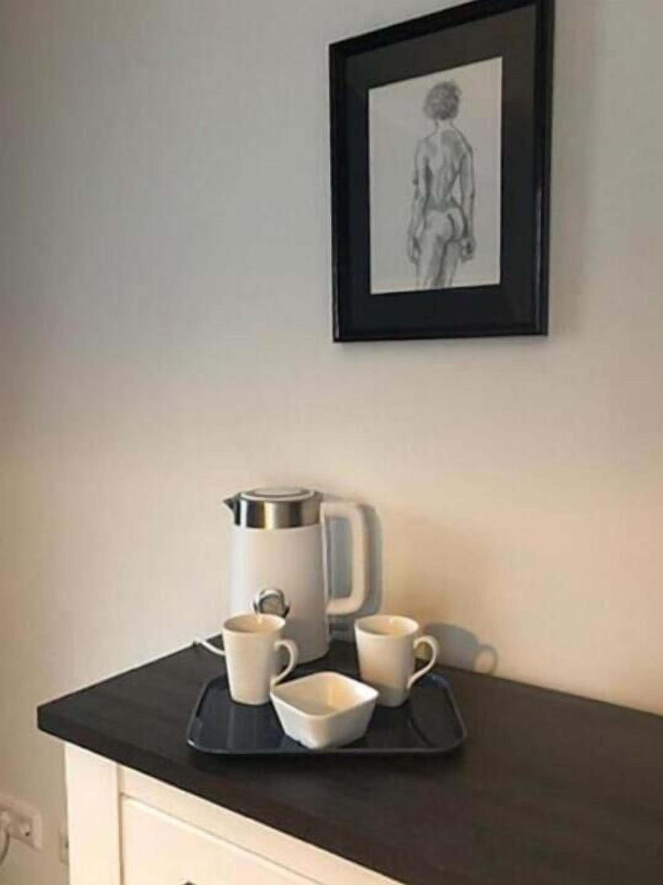 Eine Küchenarbeitsplatte mit einer Kaffeemaschine, zwei Tassen und einem Tablett.