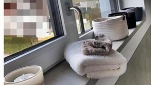 Un bany amb finestra, un lavabo i una barra per a tovalloles.