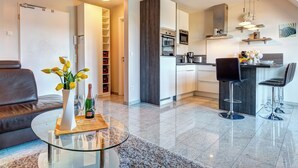 A modern apartment with a living room, kitchen, and dining area. - Residenz am Balmer See, apartment 67 with sauna, lake view and WLAN (Balm)