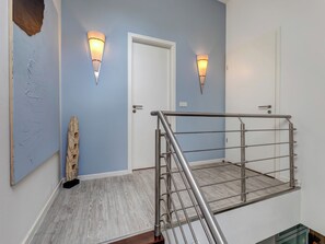 A modern staircase with metal railings, a wooden floor, and light blue walls. - Residenz am Balmer See, apartment 70 with sauna, WLAN & 1 bedroom for 2 guests (Balm)