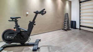 An indoor gym with an exercise bike, a rack of dumbbells, and a wall-mounted pull-up bar. - Residenz am Balmer See, Whg. 47 - Wellness, sauna and lake view (Balm)