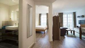 Een moderne hotelkamer met een badkamer, een bed, een zithoek en een televisie.