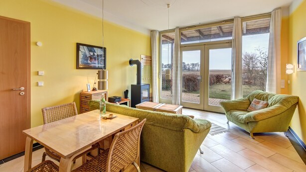 Une pièce comprenant une table à manger, des chaises, un canapé, un téléviseur et une cheminée.