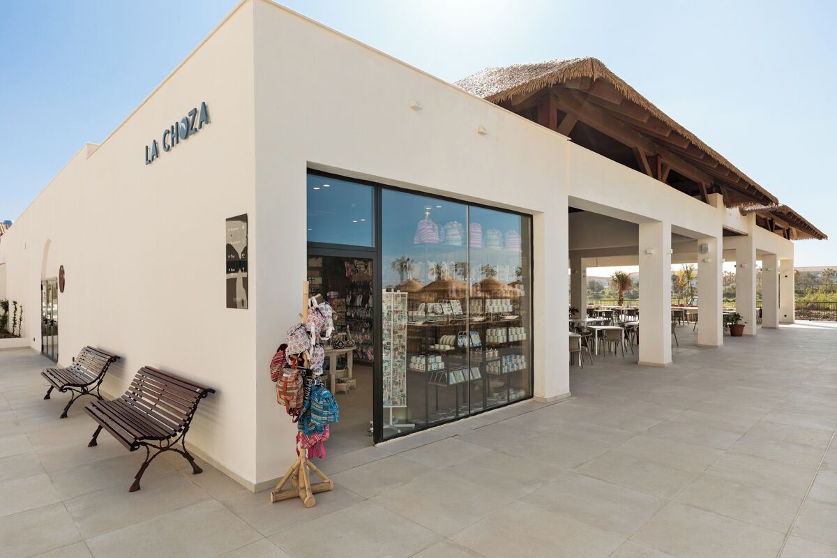 A storefront with a large glass window, a sign reading 'LA CHOZA,' and outdoor seating.