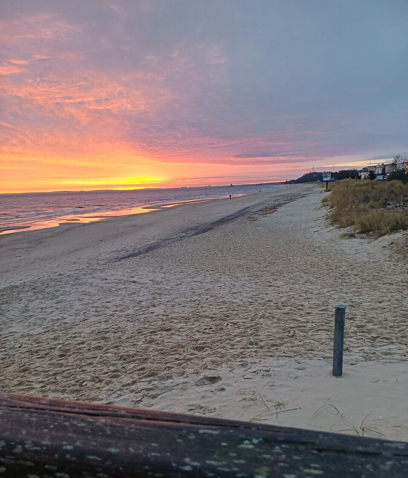 A beach with a clear sky and a sunset.