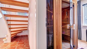 A wooden staircase leading to a room with a glass door and a wooden wardrobe.