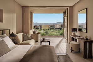 A hotel room with a bed, a desk, a chair, a small table, and a view of the outdoors. - Ikos Kissamos - All Inclusive (Kissamos)