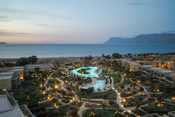 A resort with a central swimming pool, multiple buildings, and a beach in the background. - Ikos Kissamos - All Inclusive (Kissamos)
