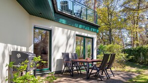 A patio with a table and chairs, a grill, and a view of trees. - House Berlin, apartment Loddiner Höft in Loddin - in the best location near the Achterwasser (Loddin)
