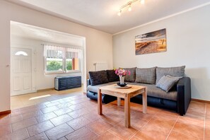 Relax in this inviting living room with a sofa, coffee table, and beautiful view through the large window.