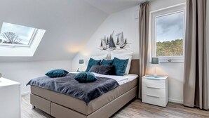 Un dormitorio moderno con una cama, mesitas de noche, una ventana con cortinas y un tragaluz.
