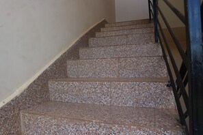 Staircase features a simple, patterned tile design and a dark handrail.