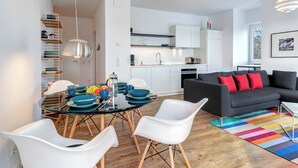 A modern apartment with a dining area, kitchen, and living room.