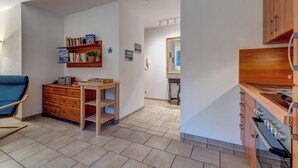 A modern kitchen with wooden cabinets and a built-in oven. - Haus Eichhorst, Whg. 03: Close to the sandy beach in Trassenheide (Trassenheide)