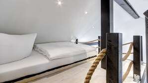 A bunk bed with white bedding, a rope barrier, and a wooden floor. - Emilia vacation apartment in Trassenheide: WiFi, garden & only 1.9 km to the beach (Trassenheide)