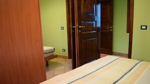 Ein Schlafzimmer mit einem Bett, einer Holztür und einer Sitzbank.
