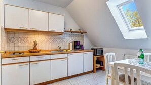 A modern kitchen with white cabinets, a wooden countertop, and a skylight. - Hansehus, Whg. 5: close to the beach in Zinnowitz with balcony and WLAN (Zinnowitz)