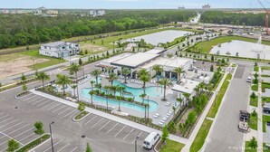 An aerial view of a hotel with a large swimming pool, multiple buildings, and a parking lot. - 10251 Ebb Tide Lane (Orlando)