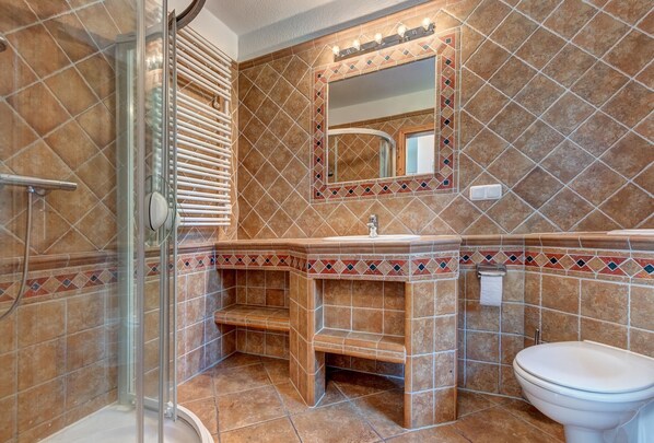 Un baño con ducha, lavamanos e inodoro.