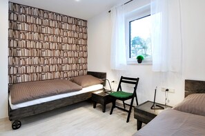 Cozy retreat with a bookshelf, single bed, and bedside table.