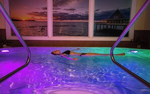 A person lying in a pool with a sunset view through the window. - Villa Waldstraße, apartment 14 in Bansin on Usedom! (Bansin)