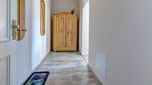 A hallway with a wooden wardrobe, a mirror, and a door with a brass handle. - Vacation apartment "Küstenwald" in the Zinnowitzer Hof on Usedom! (Zinnowitz)