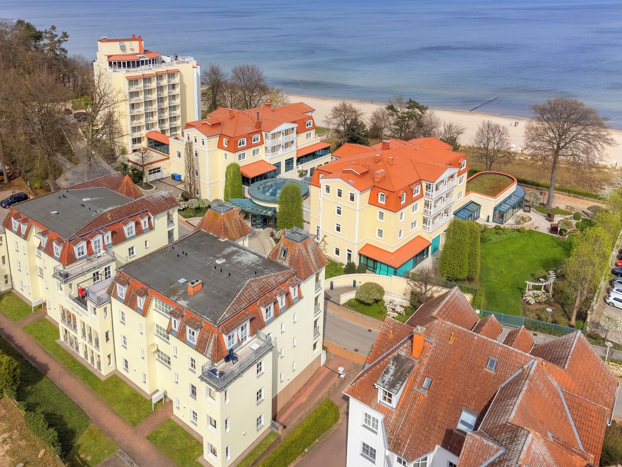 Una zona residencial costera con edificios de varios pisos, una playa y un cielo despejado.