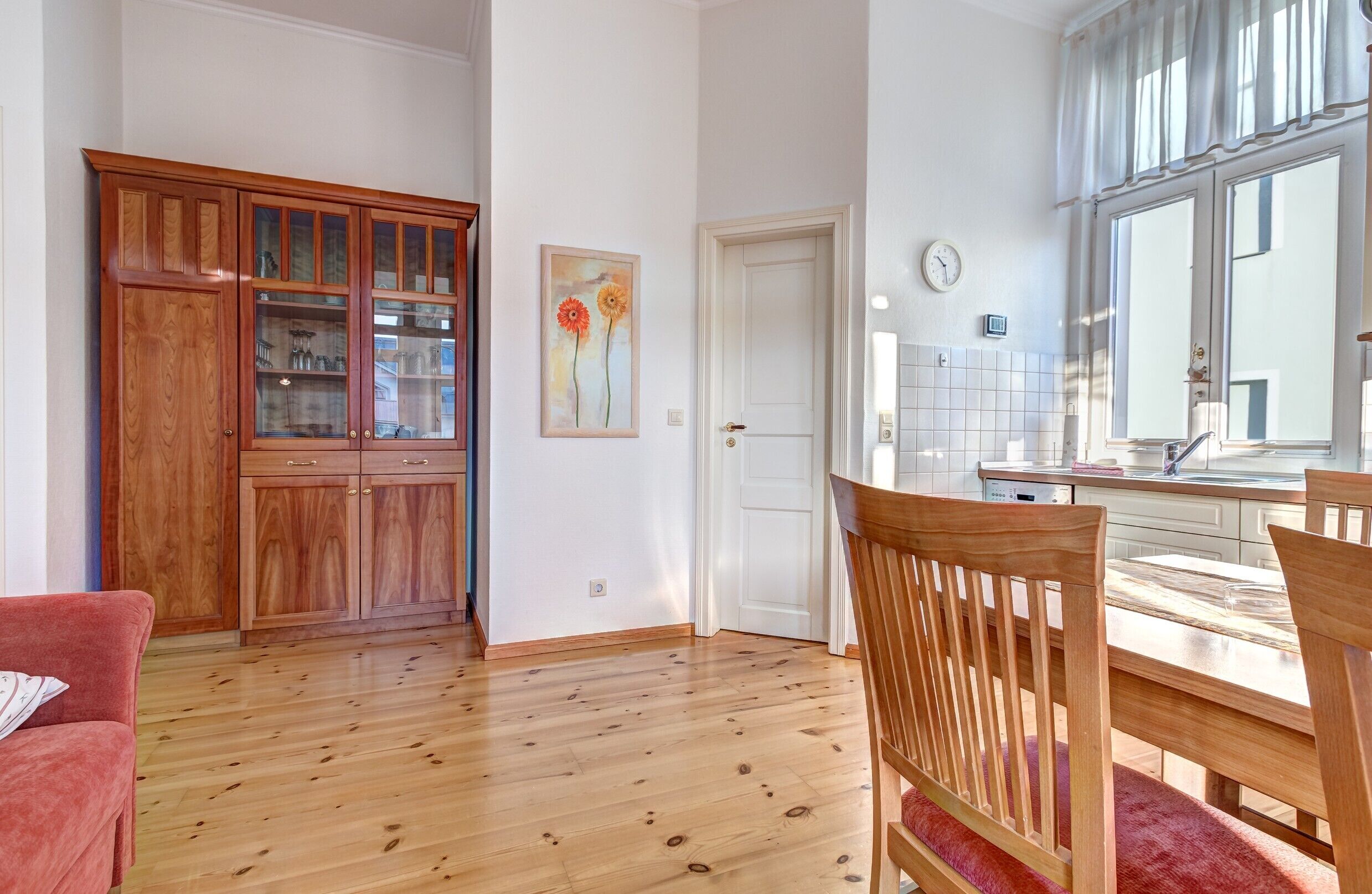 A kitchen with wooden cabinets, a dining table, and chairs.