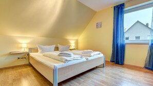 Une chambre à coucher avec un lit, des tables de chevet et une fenêtre avec des rideaux.