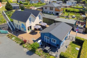 Een woonwijk met huizen, een blauw gebouw met terras en een trap die naar een garage leidt.