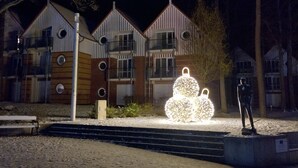 Un edificio con fachada simétrica, varios balcones y una escultura central iluminada.
