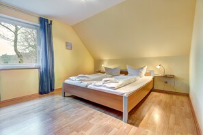 Cozy retreat with a wooden bed, bedside tables, and large window.