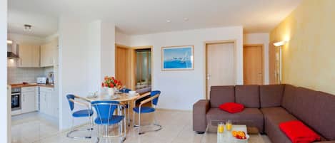 A modern apartment with a dining area, kitchen, and living room.