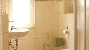 A small bathroom with a sink, toilet, and shower. - House Vincent, apartment 3 in Zinnowitz with balcony, WLAN and 4 beds (Zinnowitz)