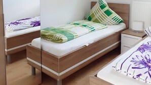 A bedroom with two beds, a mirrored closet, and a window with blinds. - House Vincent, apartment 3 in Zinnowitz with balcony, WLAN and 4 beds (Zinnowitz)