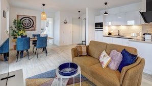 A modern apartment with a living room, dining area, and kitchen. - Bernsteinquartier, Whg. 02.25 in Kölpinsee - Stylish 2-room oasis near the Baltic Sea (Kölpinsee)