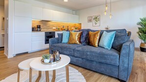 A modern living room with a grey sofa, white coffee table, and a round rug. - Bernsteinquartier, Mister Bernstein, Whg. 01.08 in Kölpinsee - pure relaxation (Kölpinsee)