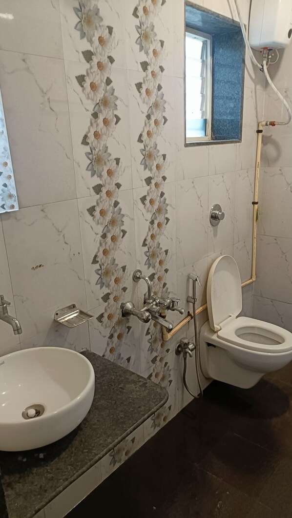A bathroom with a marble sink, a toilet, and a shower. - Golden Heaven (Mahabaleshwar)