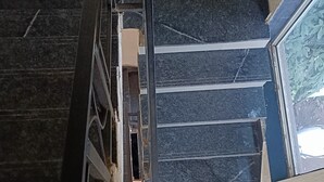 A staircase with dark marble steps and a metal handrail. - Golden Heaven (Mahabaleshwar)