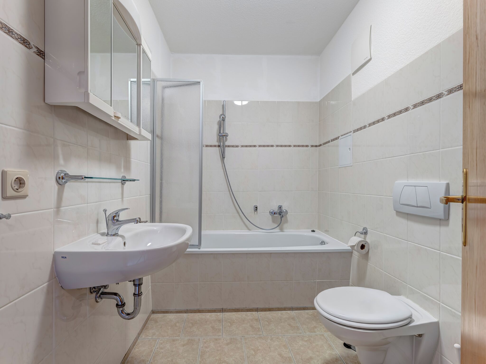 Un bagno con lavandino, WC e doccia.