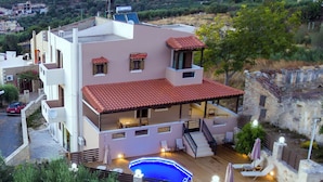 A modern two-story house with a swimming pool, a covered patio, and a view of the surrounding landscape. - Amalia Villa with Private Pool (Mylopotamos)