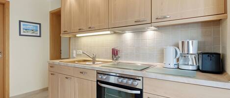 Een koelkast, een oven, een kookplaat, een koffiezetapparaat/waterkoker