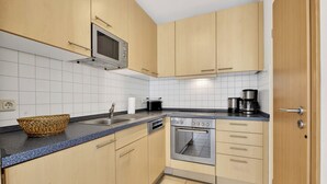 A kitchen with wooden cabinets, a microwave, a coffee maker, and a dishwasher.