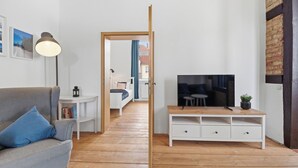 Un salon moderne avec un canapé, un meuble pour la télévision et un plancher en bois.